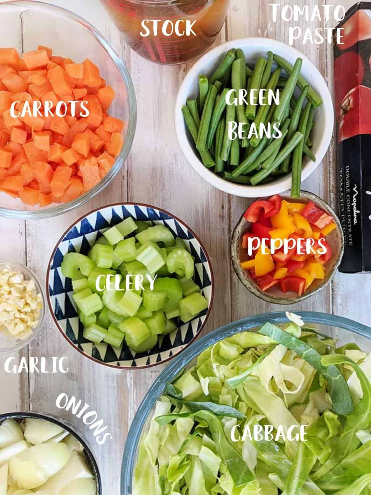 The ingredients to make low calorie cabbage soup set out on a table.