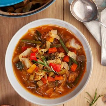 A bowl of low calorie cabbage soup on a wooden table.