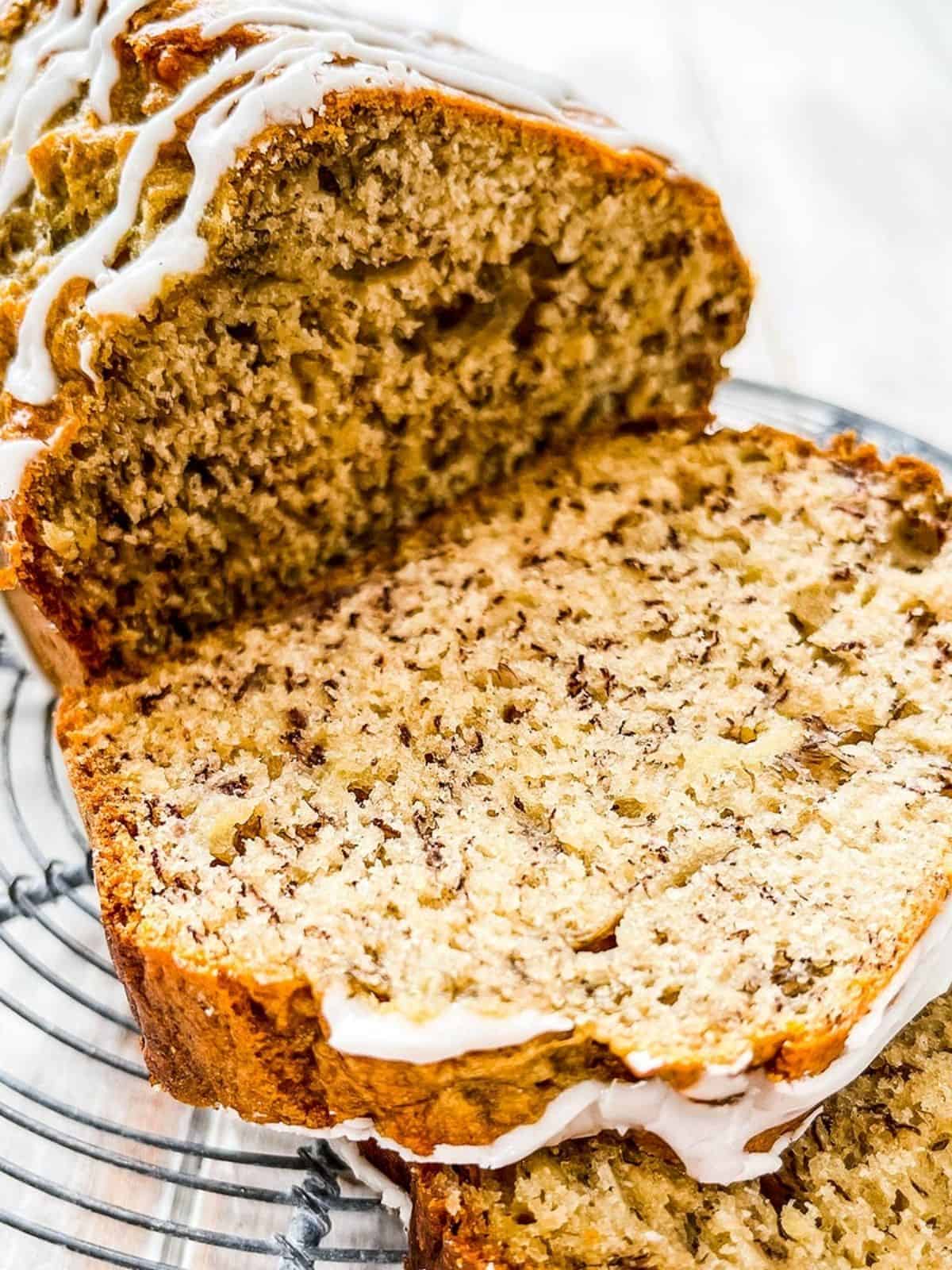 A close up shot of sliced banana loaf on a wire rack.